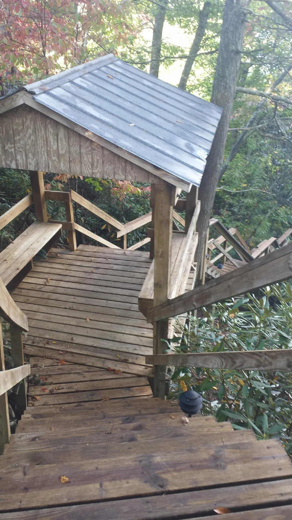 Metal roofed shelter over wooden steps on a wooded walkway — Skylight Repair & Installation work by our crew in Fairmount