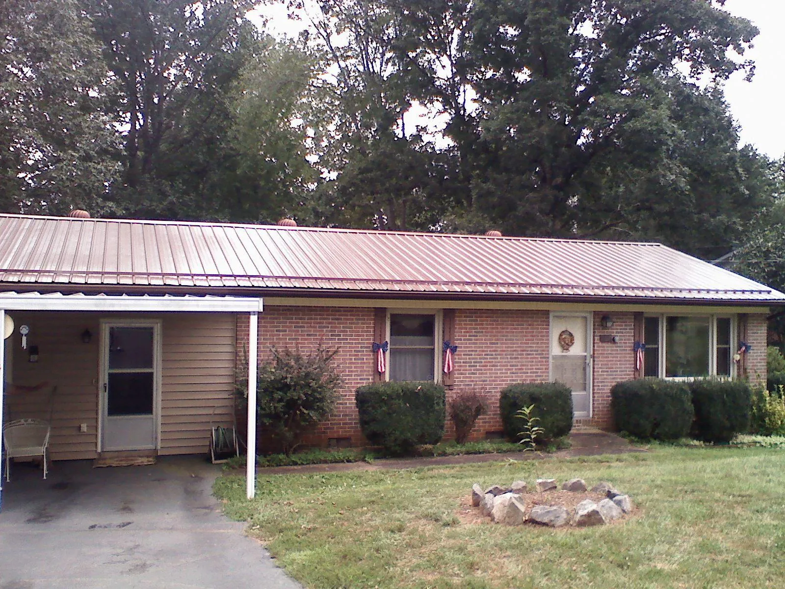 Bronze metal roof and carport on a brick ranch home — Roof Repair work by our crew in Fairmount